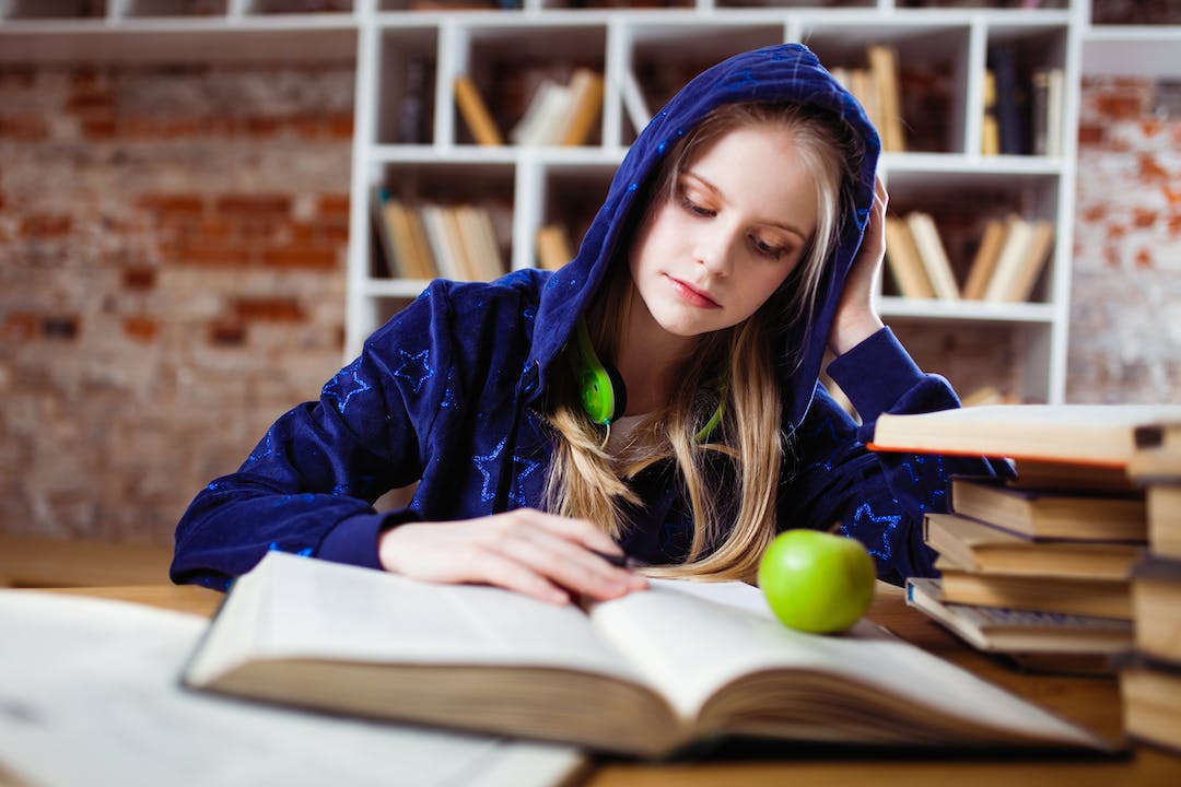 ragazza che studia in biblioteca