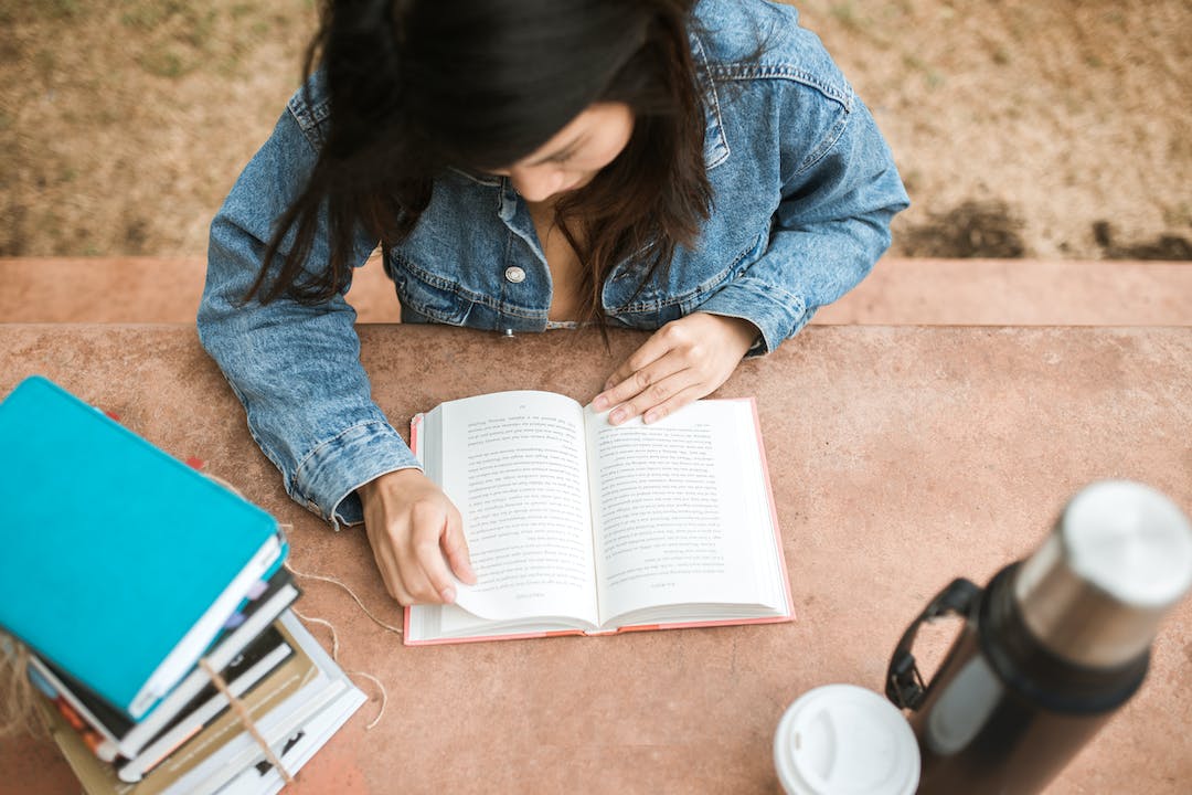 ragazza che legge un libro vista dall'alto