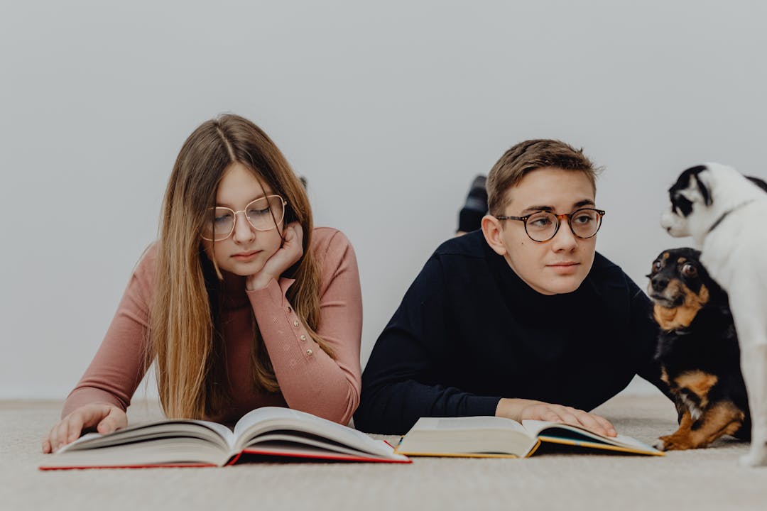 ragazzi che studiano distratti da due cagnolini