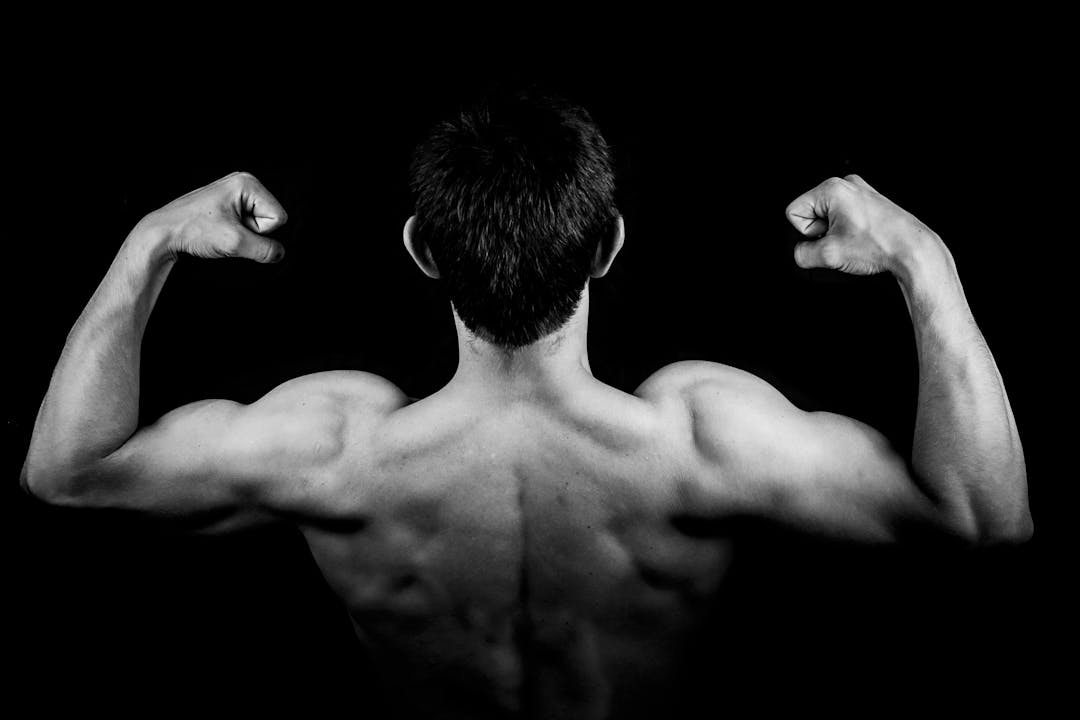 ragazzo che fa veder ei muscoli delle braccia e delle spalle